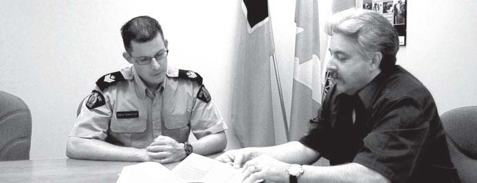 Le sgt Steve Fassbender de la GRC discute avec l’enquêteur Paul Woods du rôle du Bureau de l’ombudsman des vétérans et des programmes d’ACC.