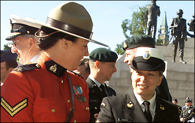 A member of the Royal Canadian Mounted Police and a member of the Canadian Forces prepare Canadian Peacekeeping Service Medals to be presented.