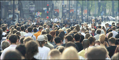 A very crowded pedestrian area in the downtown of a city. No individuals can be distinguished.